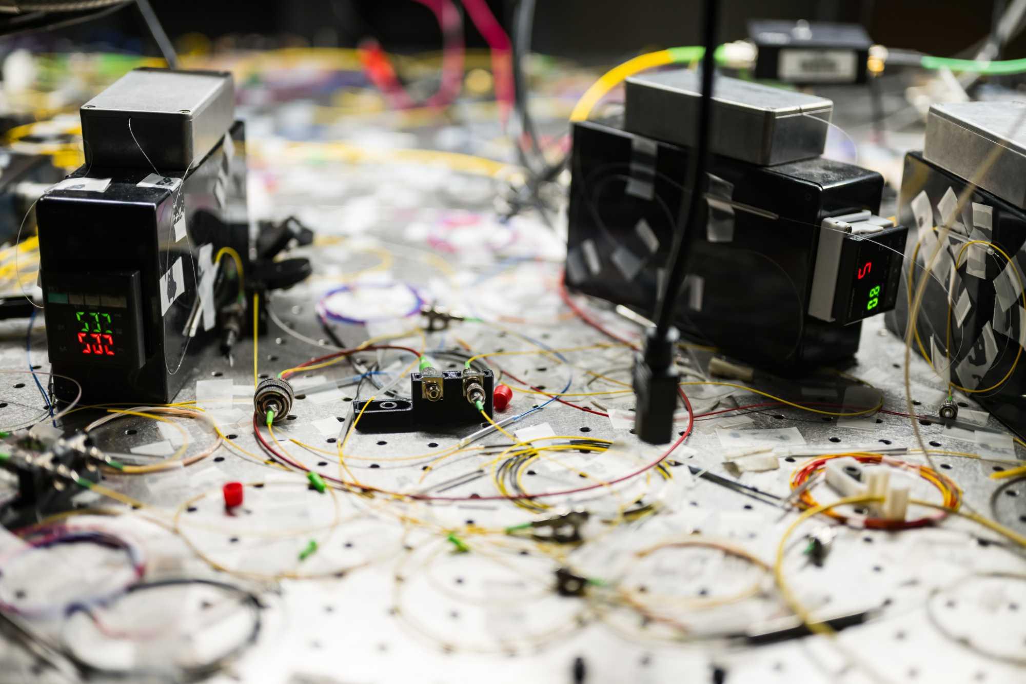 Optical equipment setup that uses surface acoustic waves for connecting and controlling hybrid quantum devices.